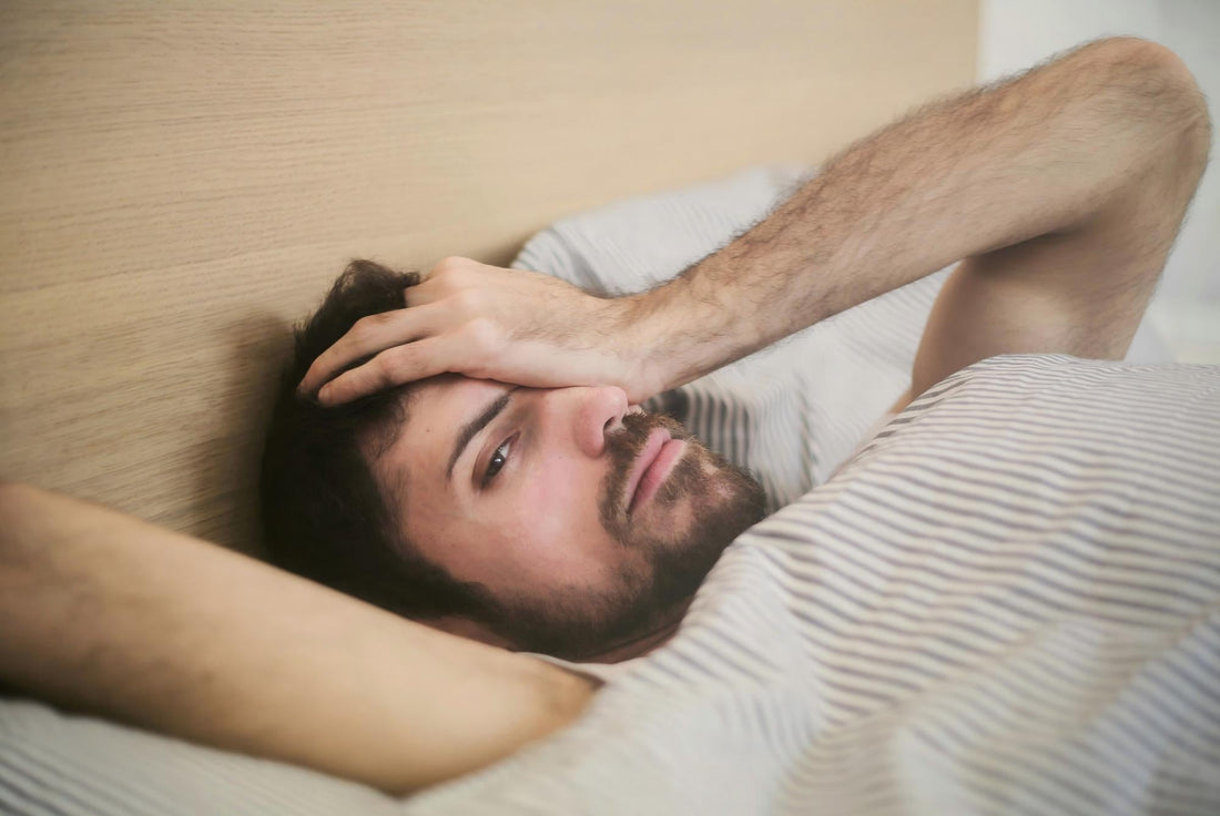 A person waking up tired in bed despite a full night’s sleep, illustrating the frustration of persistent fatigue.