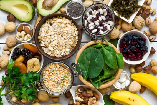 A variety of magnesium-rich foods including spinach, almonds, and pumpkin seeds displayed on a wooden table.