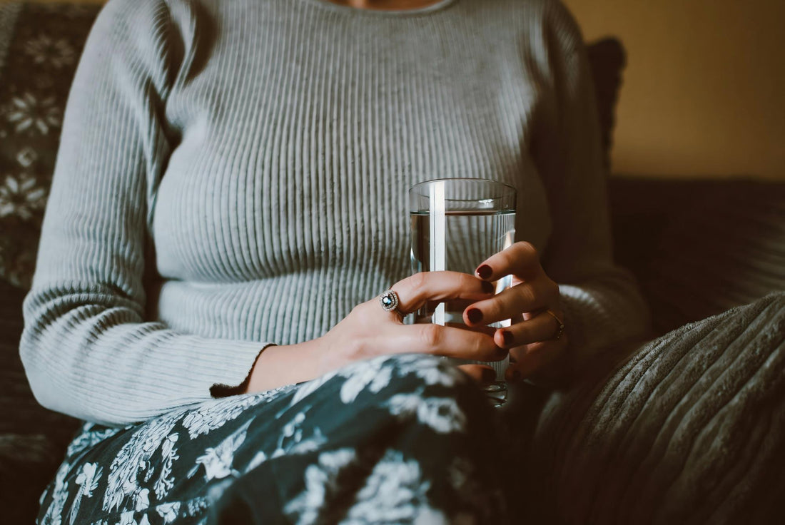 Person drinking water first thing in the morning to boost energy.